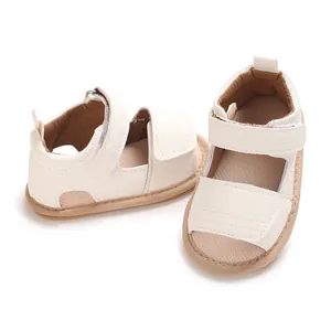 Détail de sandales pour bébé en cuir PU blanc avec semelles en caoutchouc souples.