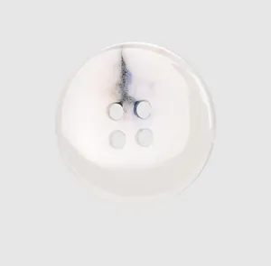 Primer plano de elegante botón cerámico con porcelana blanca y patrón de tinta suave