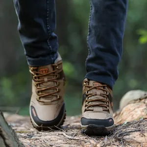 Primer plano de botas de senderismo marrones de caña alta para hombre en un bosque