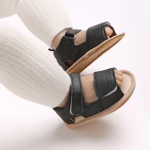 Gros plan latéral de sandales bébé en cuir PU noir avec semelle caoutchouc souple