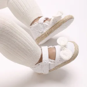 Gedetailleerde weergave van witte baby prinsessenschoenen met kant en strikdetail