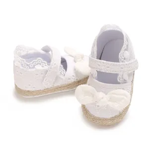 Gedetailleerde weergave van witte kanten babyprinsessenschoenen met strik en zool
