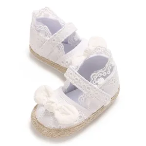 Detailopname van witte kanten babyschoentjes met strik en zachte antislipzool