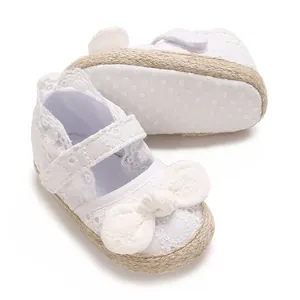 Gedetailleerd overzicht van witte kanten babyschoentjes met strik en antislipzool