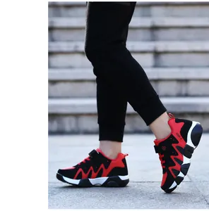 Detailed action shot of boys' red and black running shoes on outdoor stone stairs