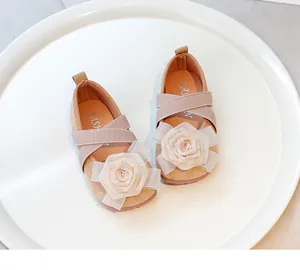 Primer plano de zapatos de princesa beige con una rosa de tela y correas cruzadas