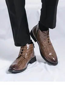 Gros plan de bottines pour hommes en motif crocodile marron avec fermeture éclair.