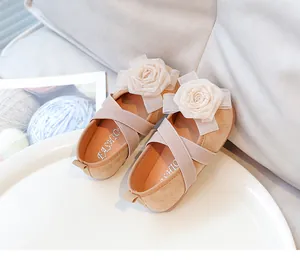 Detalle de manoletinas para niños color albaricoque con rosas de tela y tiras elásticas