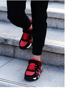 Detail action shot of boy's red and black non-slip running shoes on outdoor stone stairs