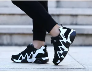 Detail view of black and white boy's running shoes featuring durable non-slip soles.