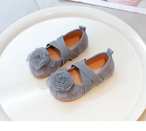 Vista detallada de zapatos de princesa grises para niños con una gran flor de tela decorativa