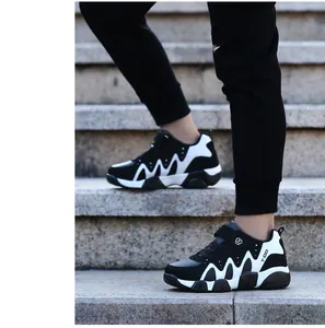 Detailed side view of boys' black and white anti-slip sports sneakers on stone stairs
