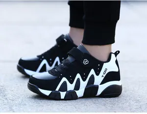 Close-up of boys' black and white sports shoes with wavy patterns and velcro straps