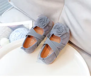 Vista detallada de zapatos de princesa grises para niña con rosa de tela y correas elásticas.