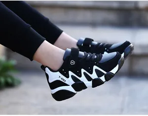 Detailed side view of boy's durable black and white sports sneakers for autumn