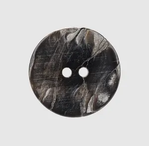 Macro view of high-end dark marbled shell button with two-hole design for luxury clothing