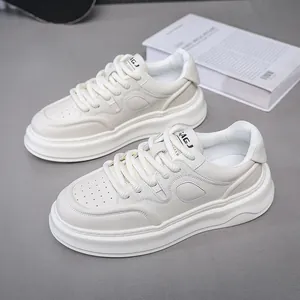 Dettaglio di scarpe da ginnastica con zeppa spessa color crema da uomo su sfondo grigio