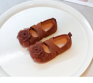 Primer plano de la rosa de tela decorativa y las correas cruzadas elásticas en zapatos marrones