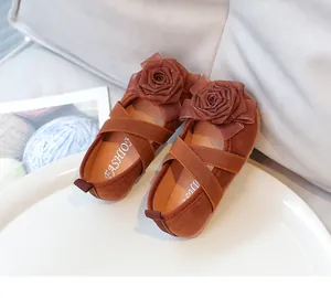 Detalle de zapatos de princesa marrón para niña con flores y correas elásticas