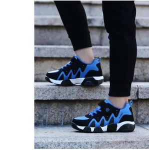 Side view of blue and black boys sports shoes shown while walking on outdoor stone stairs