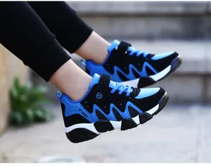 Side view of boys' blue and black athletic sneakers with durable traction soles