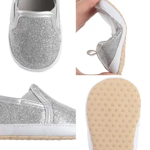 Close-up of silver glitter baby shoes featuring flexible soft sole and non-slip dots.