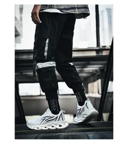Close-up of men's white mesh running shoes featuring black flame motifs and chunky blade-style soles.