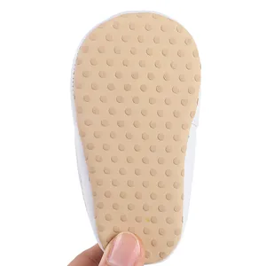 Close-up detail of the anti-slip soft sole for baby walking shoes with white polka dots