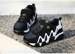 Detail of black and white boy's sneakers with durable synthetic leather upper and non-slip sole.