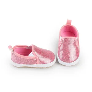 Close-up detail of pink glitter baby walker shoes featuring soft white soles and elastic