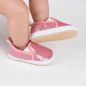 Close-up of pink glitter baby walking shoes with soft non-slip rubber soles