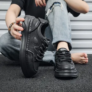 Dettaglio ravvicinato di eleganti sneakers nere da uomo con suola spessa e pelle morbida.