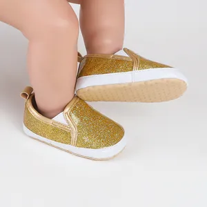 Detailed macro view of golden glitter baby pre-walker shoes with flexible soft white soles