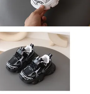 Detalle de elegantes zapatillas chunky negras para niños con motivos blancos decorativos