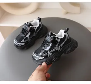 Primer plano de zapatillas chunky blancas y negras para niños con malla y cuero