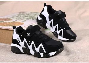 Side detail of black and white boys sports shoes featuring durable hook-and-loop straps