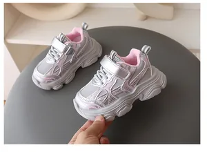 Vista lateral detallada de zapatillas chunky para niños en plata y rosa con velcro