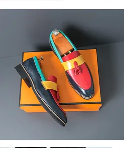 Détail de mocassins en cuir faits main multicolores avec glands sur une boîte orange