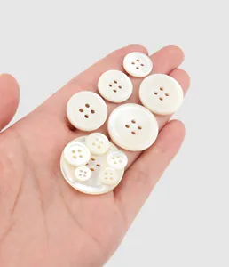 Makroansicht von hochwertigen weißen Muschelknöpfen in verschiedenen Größen in der Hand