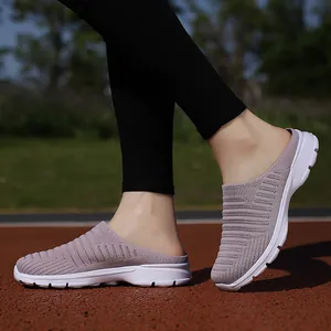 Close-up detail of breathable mauve fly-knit mule sneakers worn on a red running track