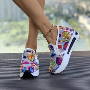 Primer plano de zapatillas de cuña de malla para mujer con vibrante bordado de cachemira