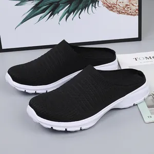 Lightweight black fly-knit breathable slip-on mules with durable white soles for travel.