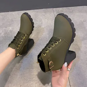 Detailansicht olivgrüner Schnürstiefeletten mit Blockabsatz und goldener Schnalle.