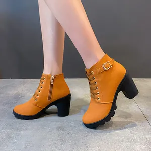 Detailansicht der orangefarbenen Stiefeletten mit Blockabsatz und Schnalle.