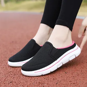Detail shot of breathable black mesh mules being worn on an outdoor running track