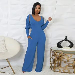 Blaues Rippstrick-Jumpsuit- und Bolero-Set, getragen von einem Modell in einem Raum
