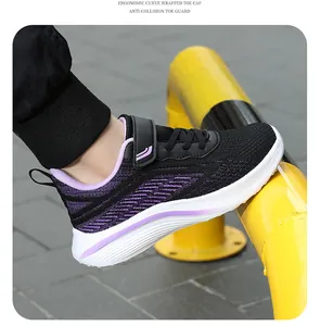 Close-up detail of girl's black and purple breathable mesh running shoe with velcro strap.