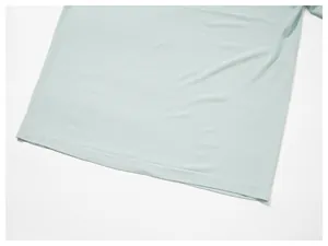 Close-up of the breathable mesh fabric and hem detail of a men's mint green t-shirt