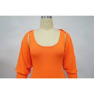 Detailansicht eines orangefarbenen, elastischen Rippstrick-Boleros und Body-Sets