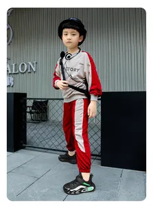 Nahaufnahme von schwarzen Kindersportschuhen mit grünen Akzenten, getragen von einem Jungen